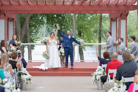 A couple is holding their hands up in the air.