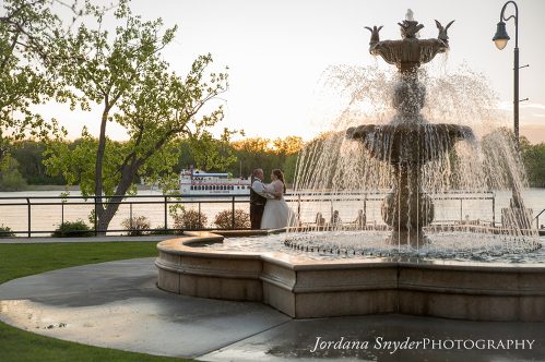 A fountain with two people standing in front of it.