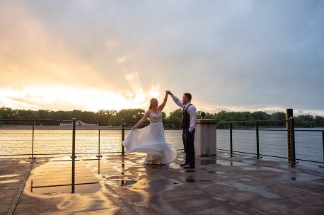 A bride and groom dancing on the pier.