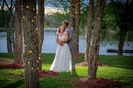 A bride and groom kissing in the woods
