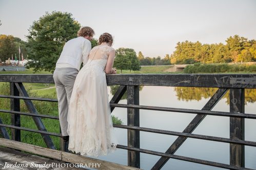 A man and woman standing on the side of a bridge.