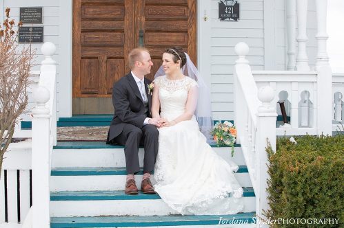 A bride and groom sitting on the steps of their wedding.