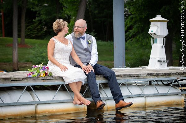 A man and woman sitting on the edge of water.