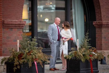 A man and woman standing outside of a building.
