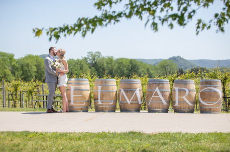 A couple kissing in front of some barrels