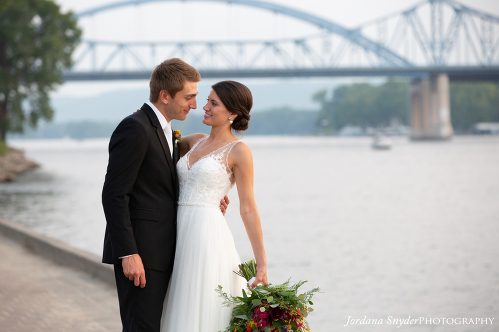 A bride and groom standing next to each other.