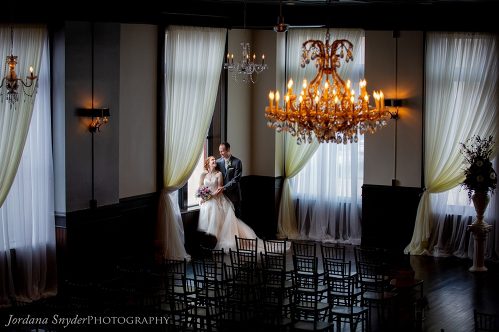 A bride and groom sitting on the back of a bench
