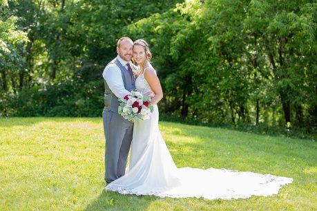 A man and woman posing for a picture in the grass.