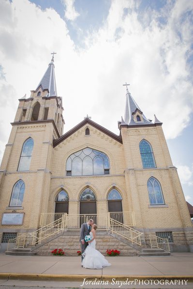A couple standing in front of a church.