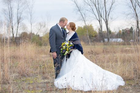 A man and woman in wedding attire standing next to each other.