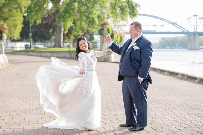 A man and woman holding hands in front of the water.