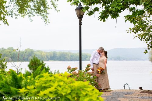 A man and woman kissing near the water.
