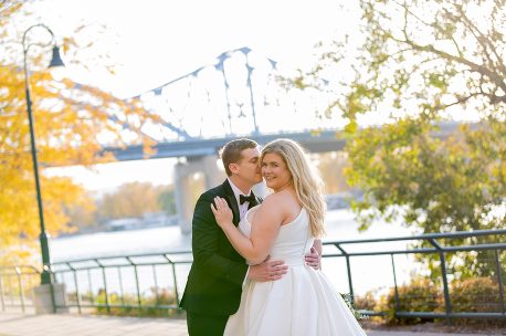 A bride and groom pose for their wedding picture.