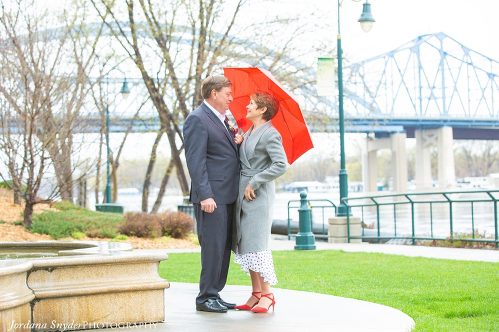 A man and woman standing under an umbrella.