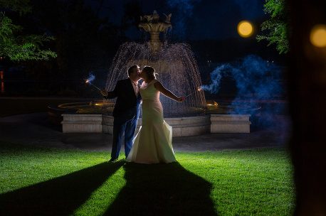 A couple is dancing in the grass at night.