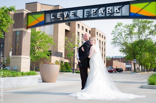 A man and woman posing for a picture under a sign.