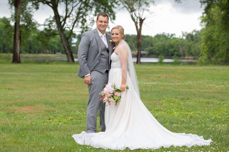 A man and woman posing for a picture in the grass.