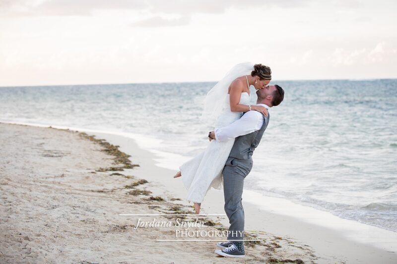 A man and woman kissing on the beach