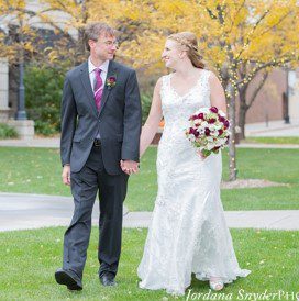 A man and woman walking in the grass.