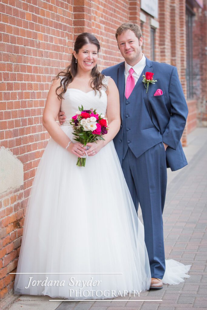A bride and groom pose for the camera.