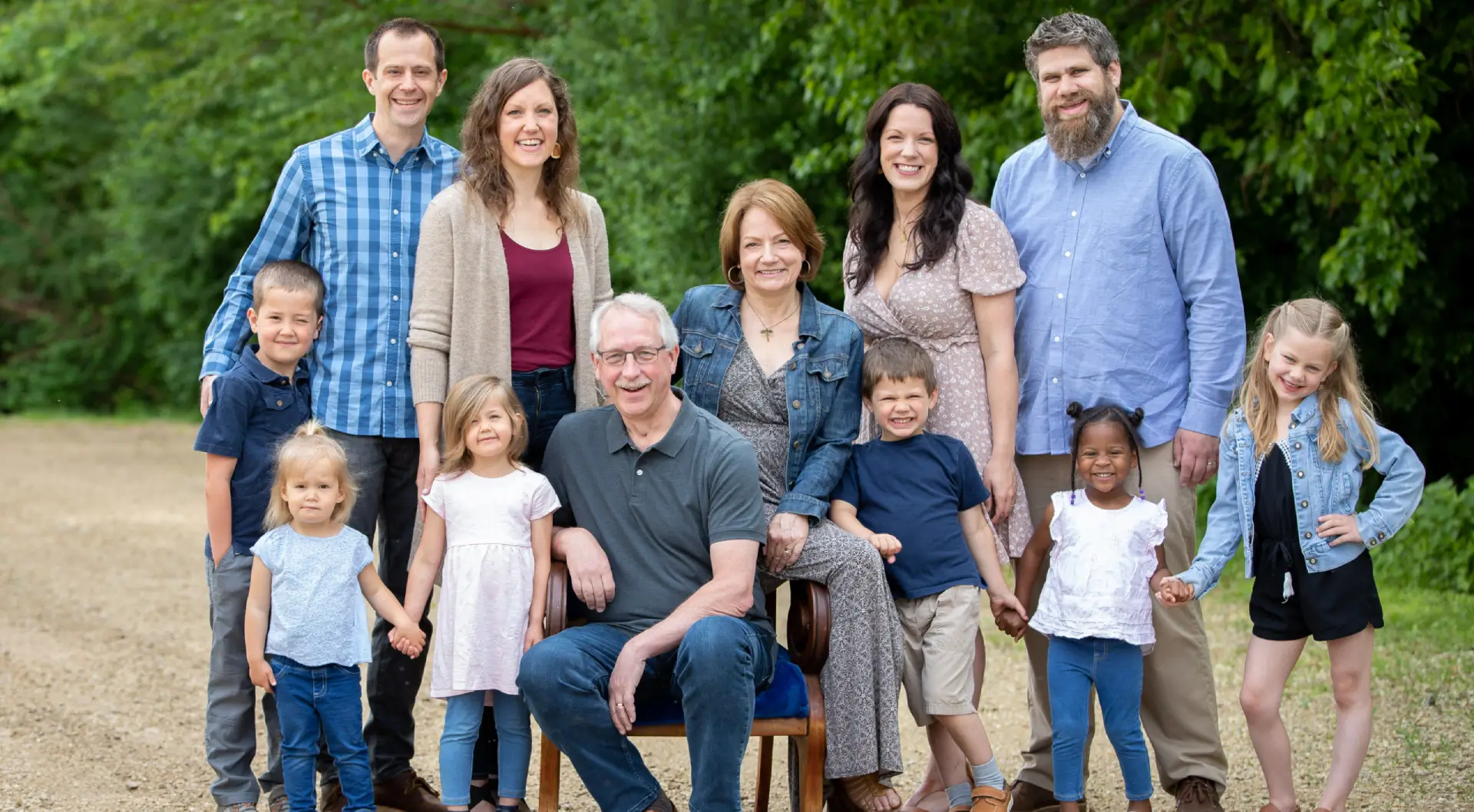 A family posing for a picture in front of trees.