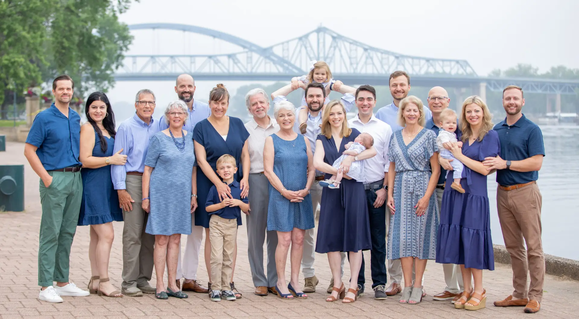 A group of people standing in front of a bridge.