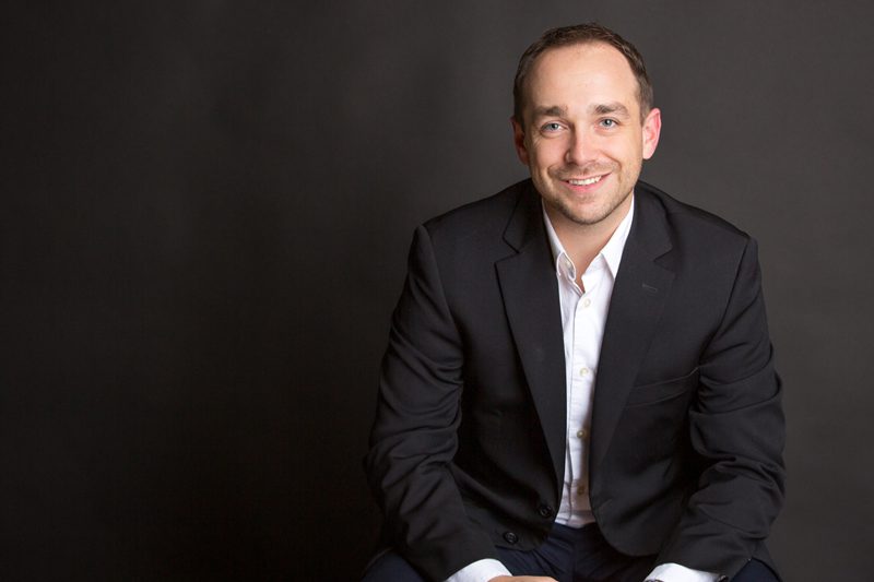 A man in a suit sitting on the ground
