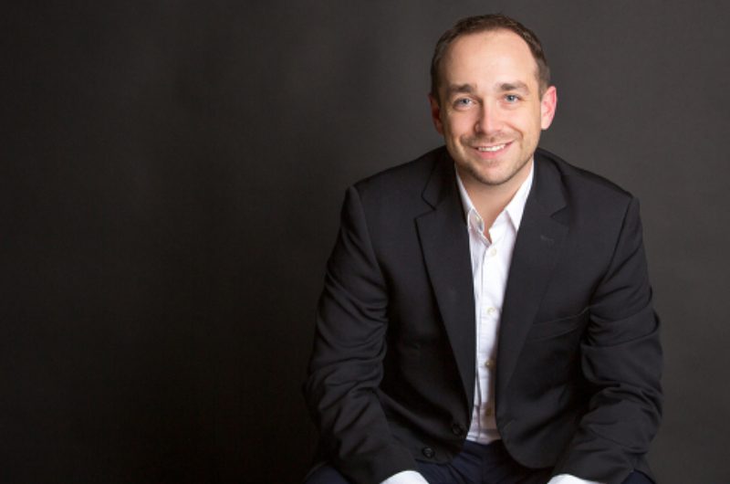 A man in a suit sitting on the ground