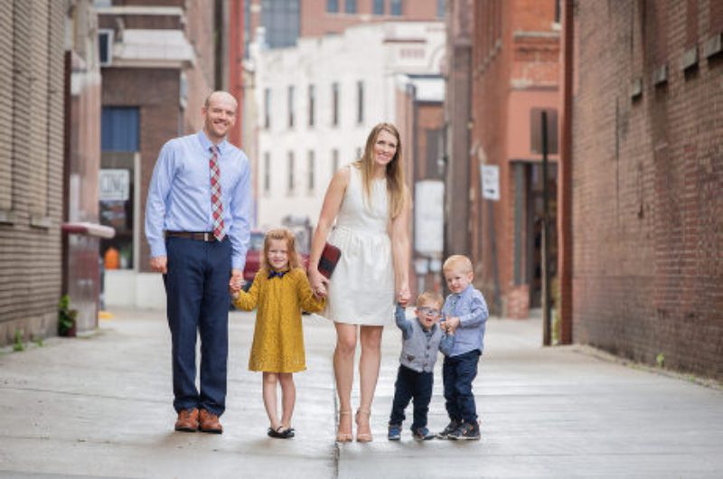 A family of four is walking down the street.
