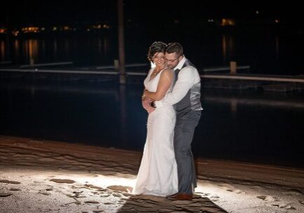 A bride and groom embracing in the dark.