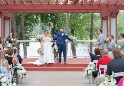 A couple is holding their hands up in the air.