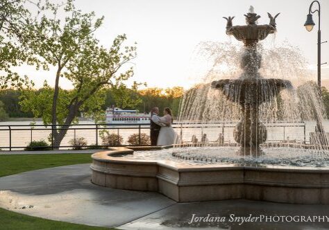 A fountain with two people standing in front of it.
