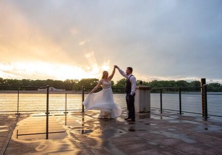 A bride and groom dancing on the pier.