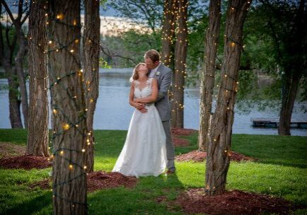 A bride and groom kissing in the woods