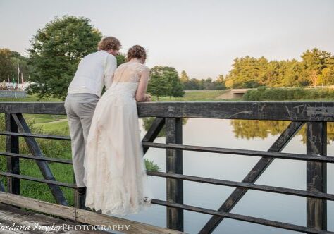 A man and woman standing on the side of a bridge.