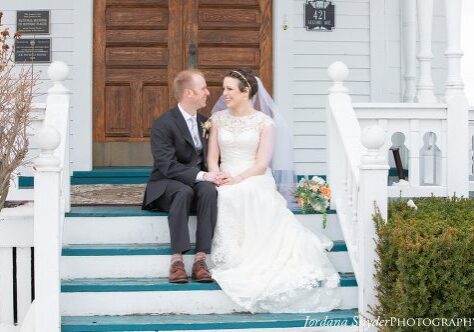 A bride and groom sitting on the steps of their wedding.