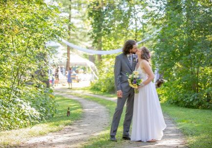 A man and woman kissing on the side of a road.