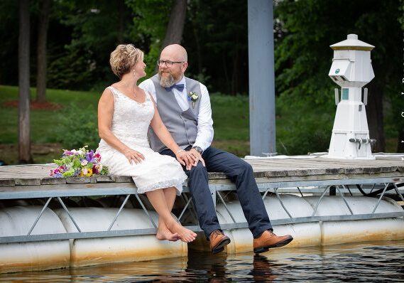 A man and woman sitting on the edge of water.