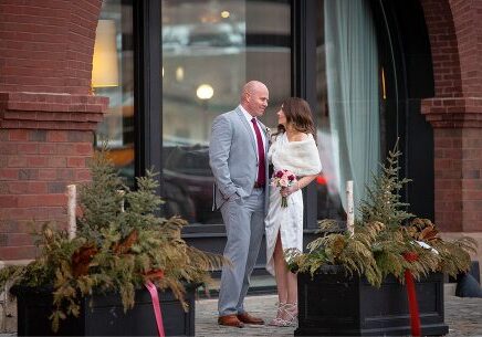 A man and woman standing outside of a building.