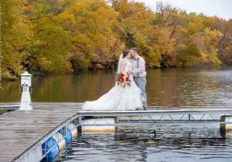 A bride and groom kissing on the dock