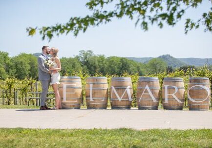 A couple kissing in front of some barrels