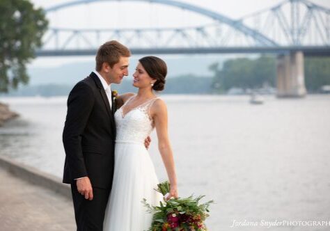 A bride and groom standing next to each other.