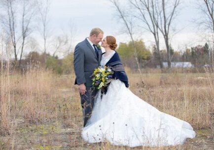 A man and woman in wedding attire standing next to each other.