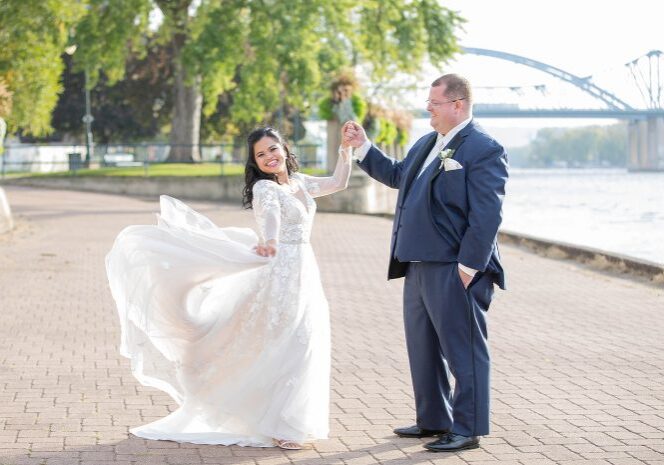 A man and woman holding hands in front of the water.