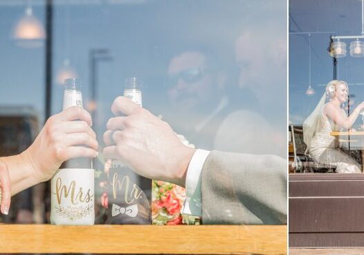 A man holding two bottles of wine in front of a window.