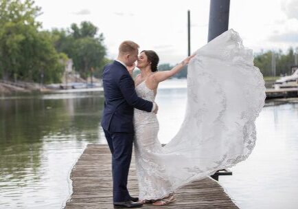 A bride and groom on the dock of their wedding day.