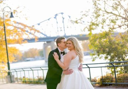 A bride and groom pose for their wedding picture.