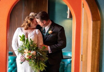 A bride and groom pose for a picture.