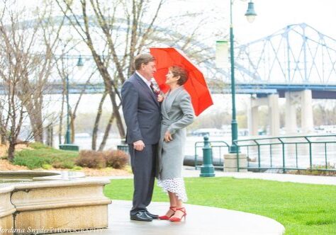 A man and woman standing under an umbrella.
