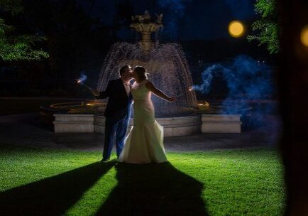 A couple is dancing in the grass at night.